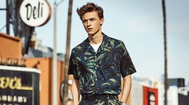 Max Barczak Embraces Sleek Spring Style from Todd Snyder Making a tropical statement, Max Barczak dons a Todd Snyder olive palm print camp collar shirt and shorts.