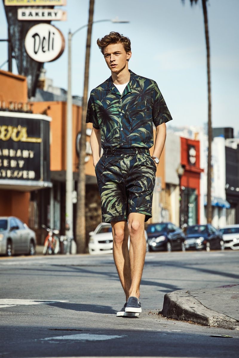 Making a tropical statement, Max Barczak dons a Todd Snyder olive palm print camp collar shirt and shorts.