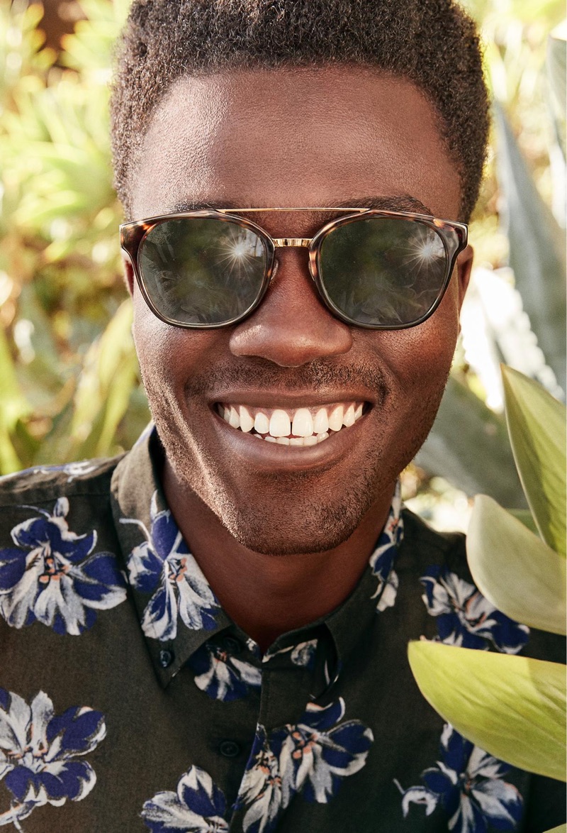 All smiles, Remi Alade-Chester rocks Warby Parker's Fairfax sunglasses in cognac tortoise with polished gold.