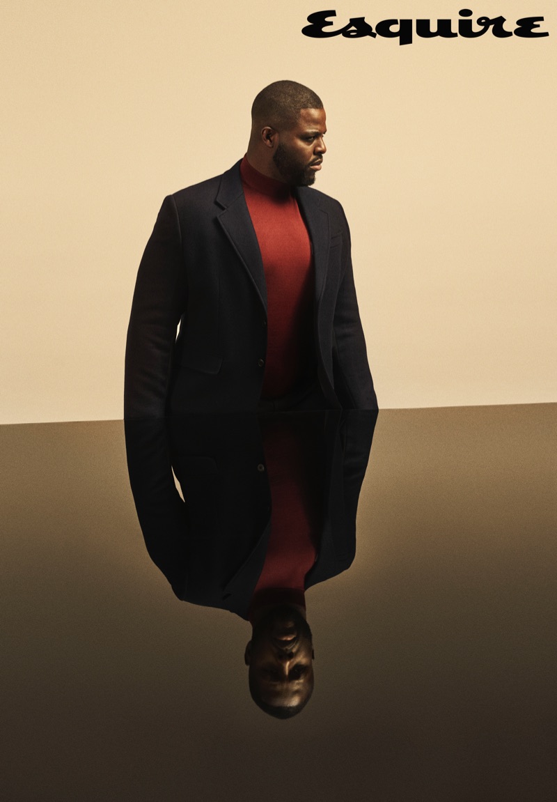 Actor Winston Duke sports a turtleneck, trousers, and jacket by Prada.