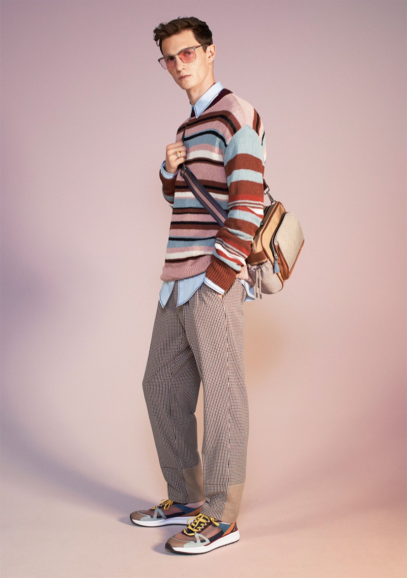 Standing out, Luc Defont-Saviard wears a striped sweater, mixed sartorial trousers, shirt, sneakers, sunglasses, and a bag from Zara's spring-summer 2019 studio collection.