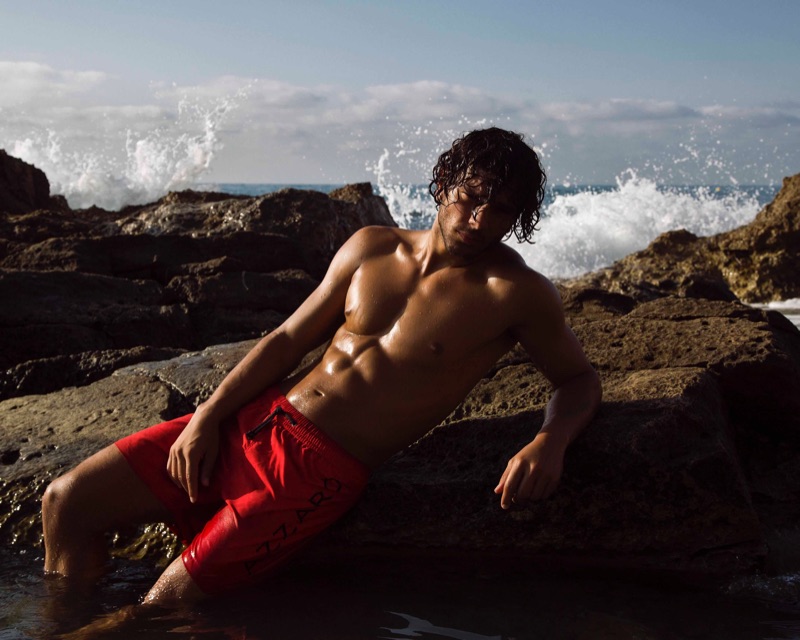 Sporting red swim shorts, Matteo Cupelli fronts Azzaro Paris' spring-summer 2019 swimwear campaign.