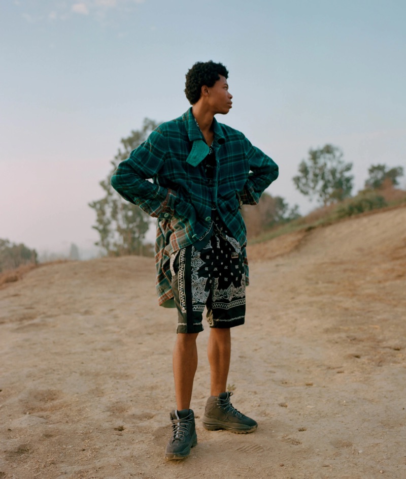 Front and center, Morocco sports a Sacai ombré flannel long jacket with belted bandana-print pleated shorts, and Yeezy boots.