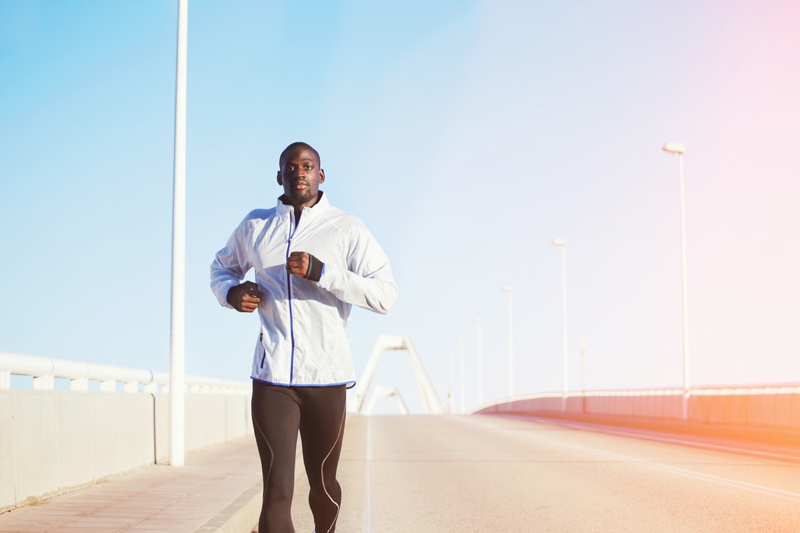 Black Man in Workout Clothes Running on Bridge
