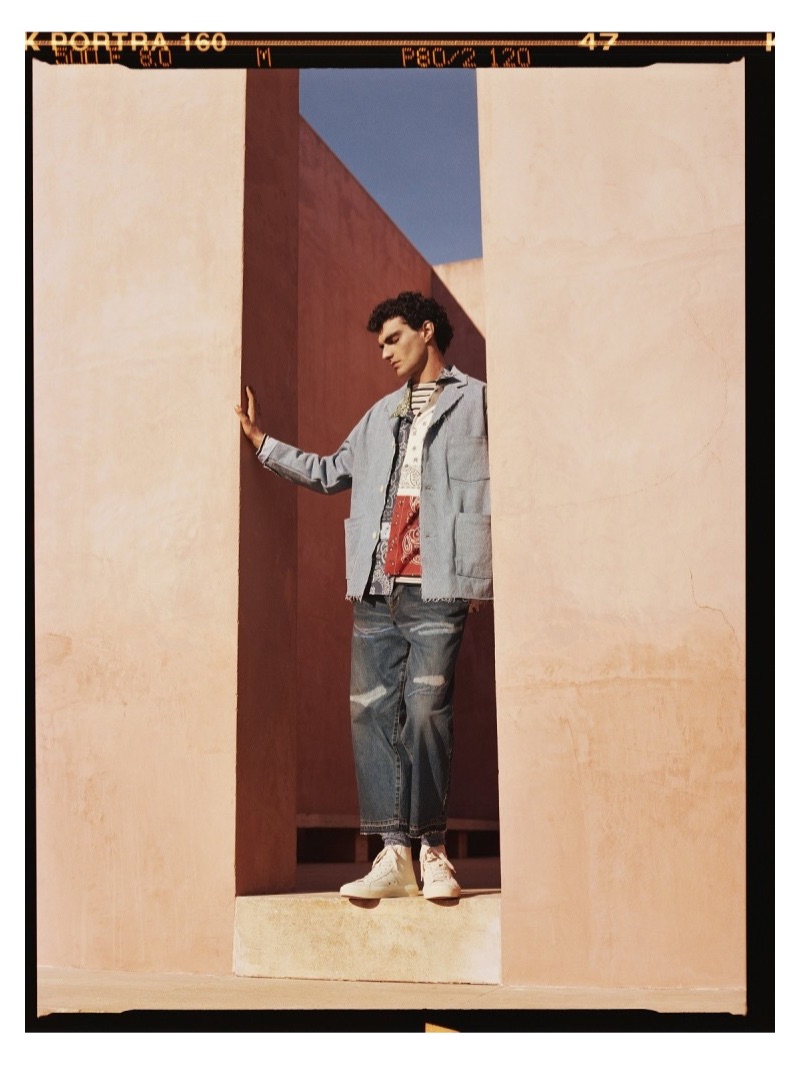 Doubling down on denim, Dylan wears an OrSlow denim jacket, Loewe patchwork shirt, Norse Projects t-shirt, Beams jeans, and Tom Ford high-top sneakers.