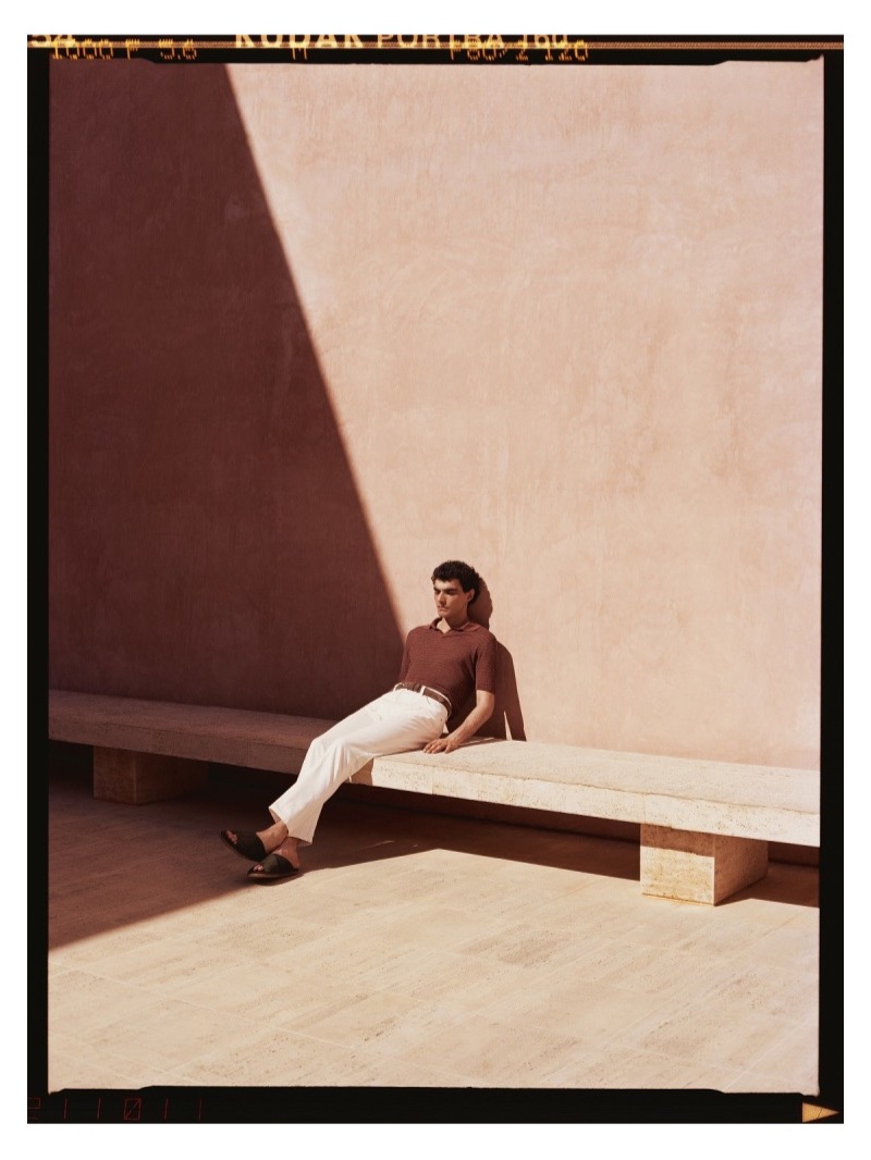 Relaxing, Dylan dons a Lardini linen polo shirt, Dries Van Noten sandals, and a Loro Piana suede belt.