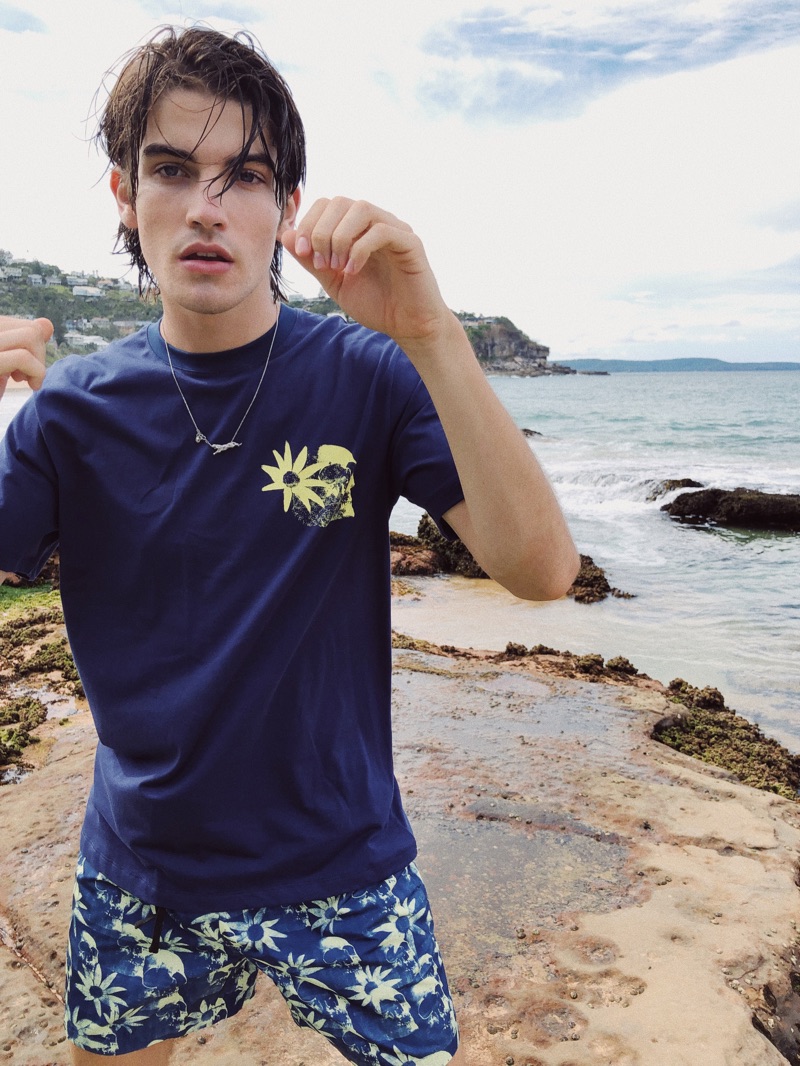 Sporting pieces from East Dane's exclusive Double Rainbouu capsule, Cal Fernie wears a short-sleeve tee and swim shorts.