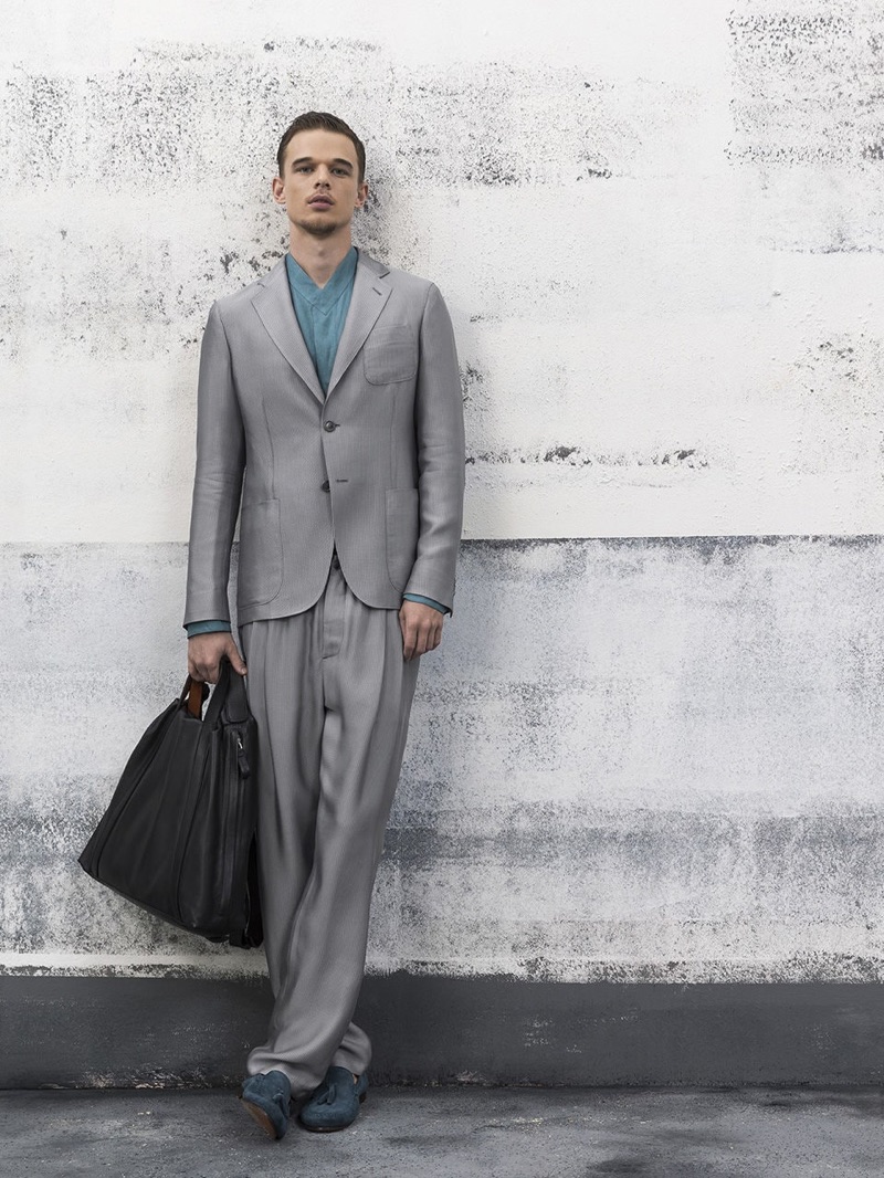 Embracing relaxed tailoring, André Bona dons a grey suit from Giorgio Armani.