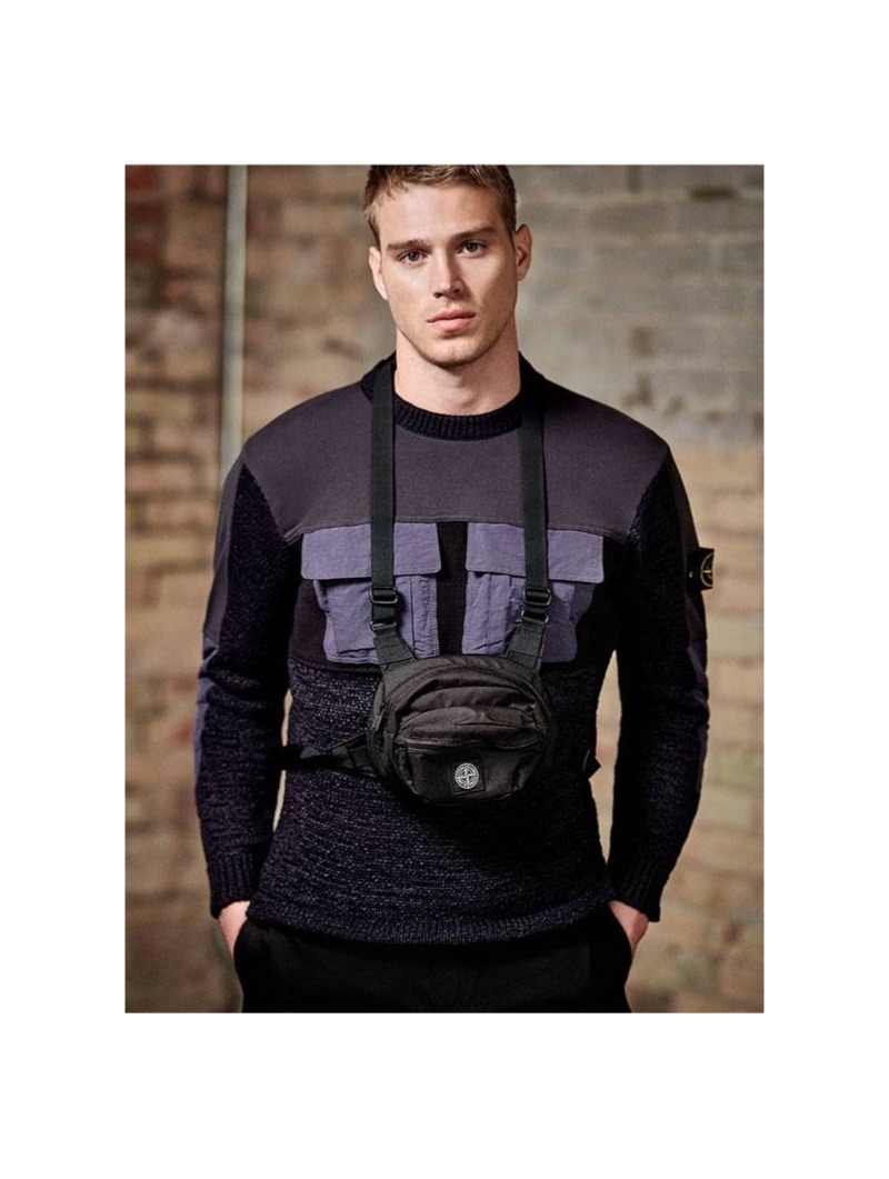 Matthew Noszka wears a Stone Island mixed-media sweater with a utility belt bag and Acne Studios shorts.