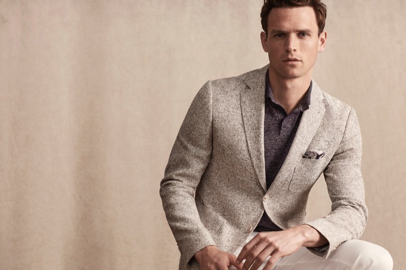 Guy Robinson dons a sleek suit jacket and polo from Lufian's spring-summer 2019 collection.