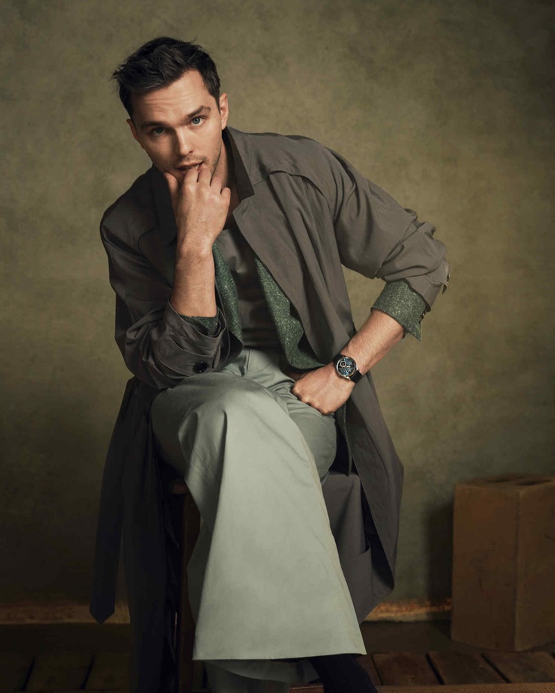 Nicholas Hoult dons a BOSS coat and leather vest with a Daks linen jacket and trousers.  He also sports a Jaeger-LeCoultre watch.