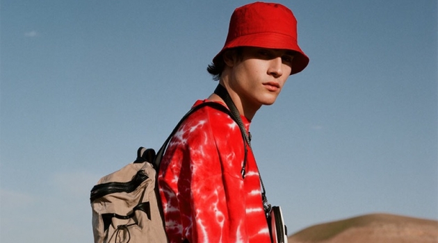 Liam Kelly Tackles Summer Style with Reserved Rocking red, Liam Kelly sports a tie-dye print t-shirt with a bucket hat and white pants by Reserved.