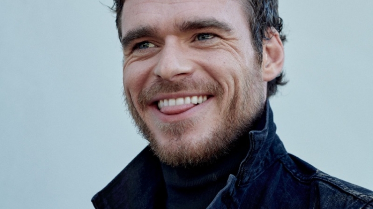 All smiles, Richard Madden wears a denim jacket by Levi's with a Prada turtleneck.