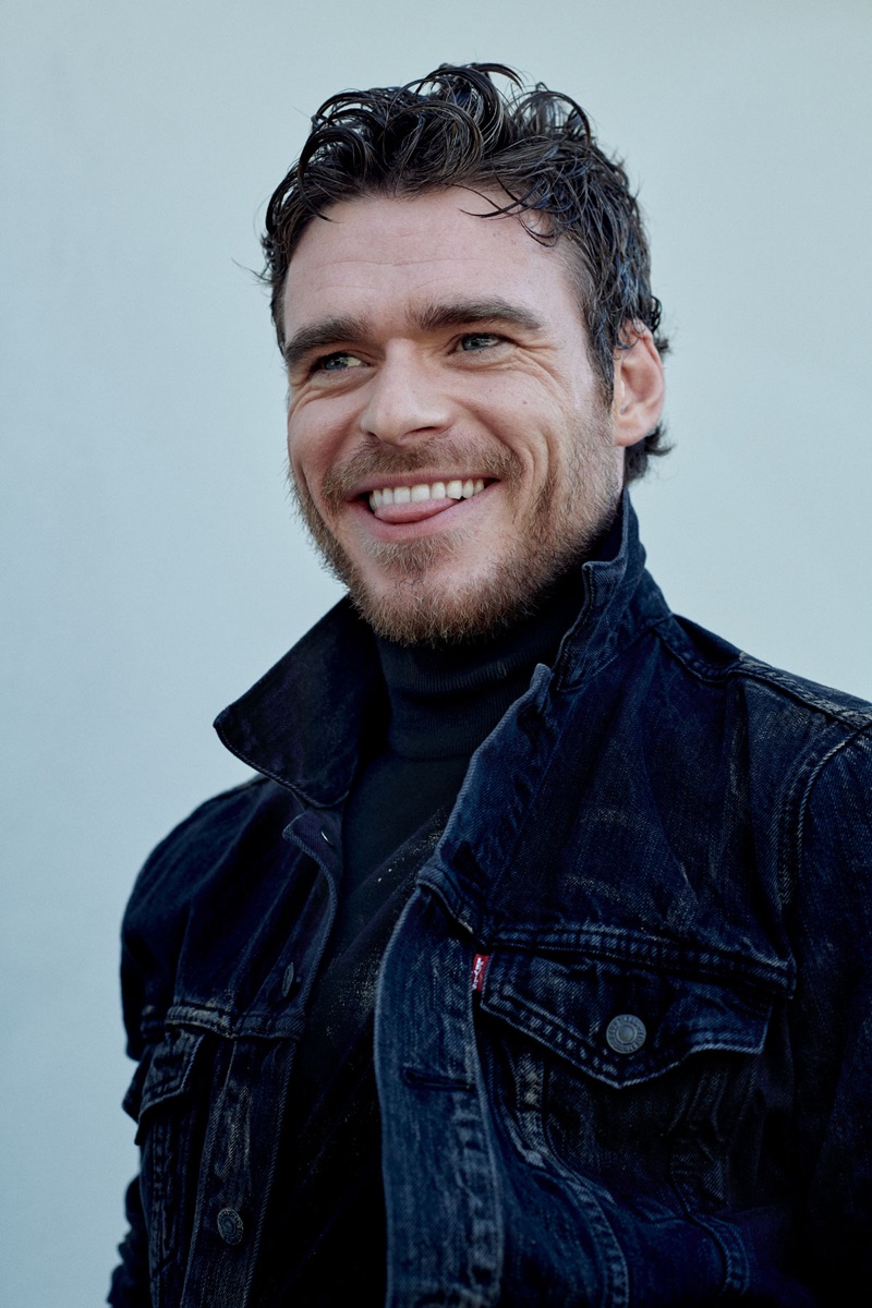 All smiles, Richard Madden wears a denim jacket by Levi's with a Prada turtleneck.