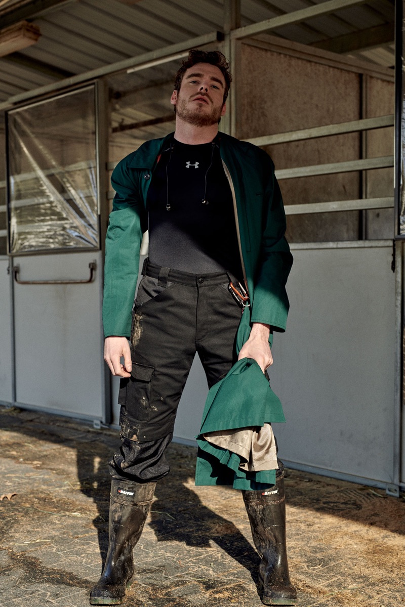 Getting his hands dirty, Richard Madden wears a Gucci coat with a top by Under Armour. He also sports Cat pants and Baffin boots.