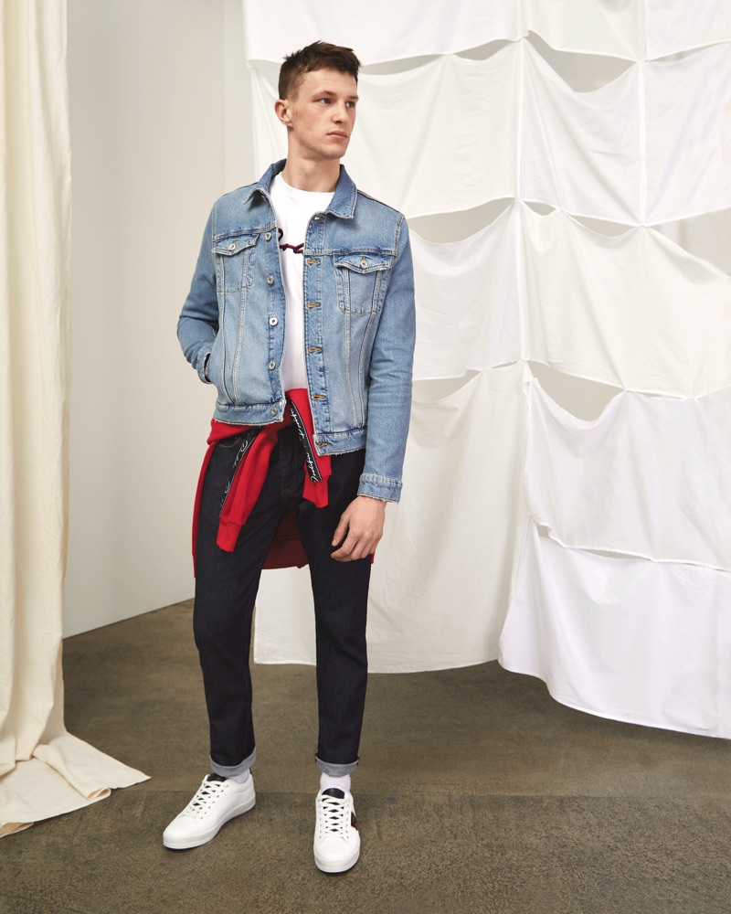 Rocking a jean jacket, Jack Buchanan sports a River Island graphic tee, sweatshirt, and slim-fit jeans as well.