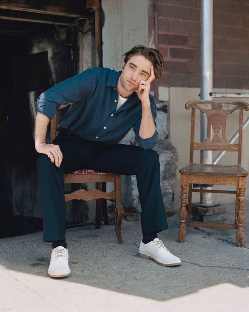 Posing for a photo, Robert Pattinson wears a Calvin Klein t-shirt with a shirt and trousers by Editions MR. » Robert Pattinson Covers The Sunday Times Style, Talks the Taming of Hollywood Posing for a photo, Robert Pattinson wears a Calvin Klein t-shirt with a shirt and trousers by Editions MR.