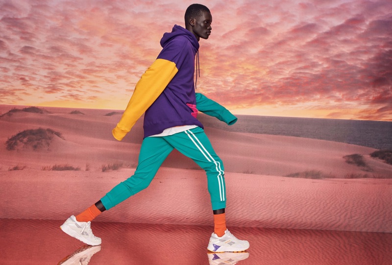 Embracing a lot of color, Monywiir Deng Dharjang wears a DJAB color block hoodie and tie-dye t-shirt with joggers. He also rocks Reebok Classic sneakers.