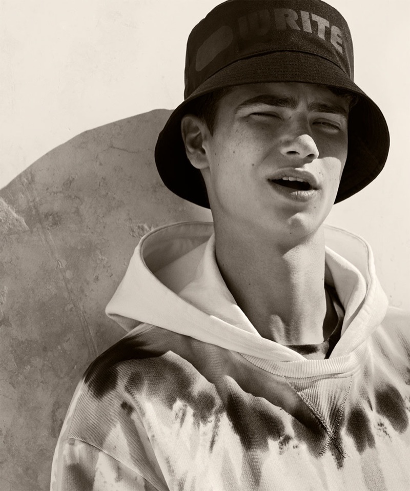 Channeling 90s style, Jonah Kozlovsky wears a bucket hat and a tie-dye hoodie from Zara.