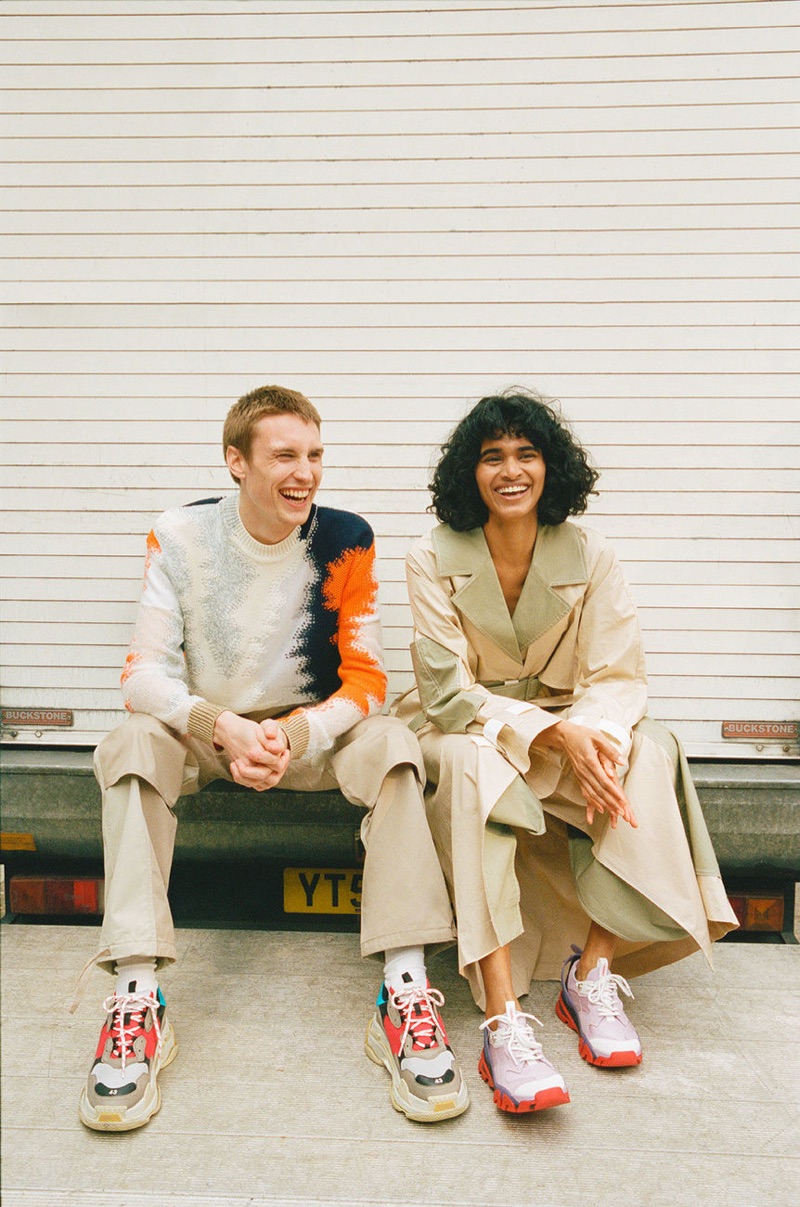 Sitting for a photo, Michael Sharp rocks a Jil Sander sweater, Jacquemus trousers, and Balenciaga sneakers.