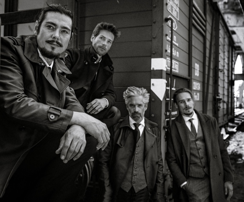 Left to Right: Chris wears suit Drykorn, coat Zalando Essentials, and shirt Angelo Litrico. Julian wears suit Dolce & Gabbana, shirt Seidensticker, and coat BOSS. Soehnke wears suit The Kooples, shirt BOSS, vest Voboom, and coat Zara. Ric wears suit Selected Homme, shirt Suitsupply, and coat Pier One.