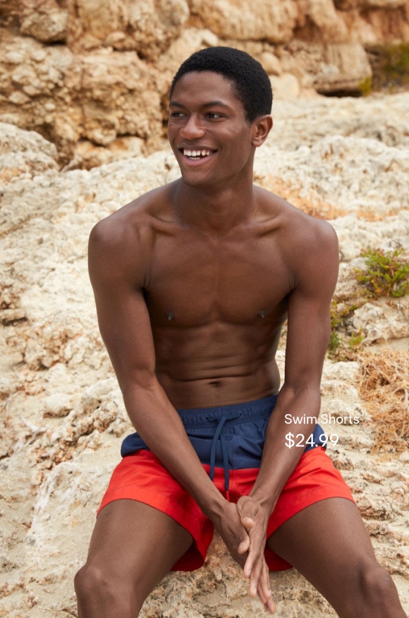All smiles, Hamid Onifade rocks red and blue swim shorts from H&M.