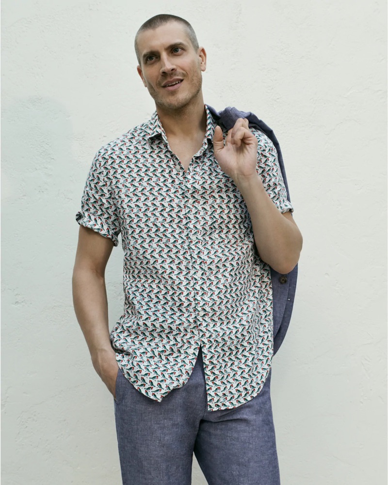 Front and center, Mike Guenther sports a J.Crew Ludlow slim-fit unstructured suit jacket in cotton-linen with matching suit pants. A J.Crew short-sleeve linen shirt with a baby birds print completes his look.