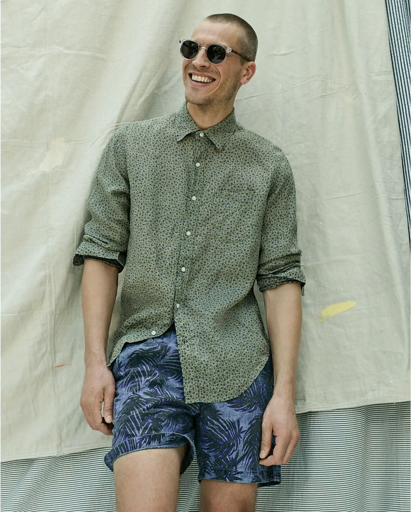 All smiles, Mike Guenther dons a J.Crew Albini Italian linen floral print shirt, indigo palm print dock shorts, and Wainscott sunglasses.