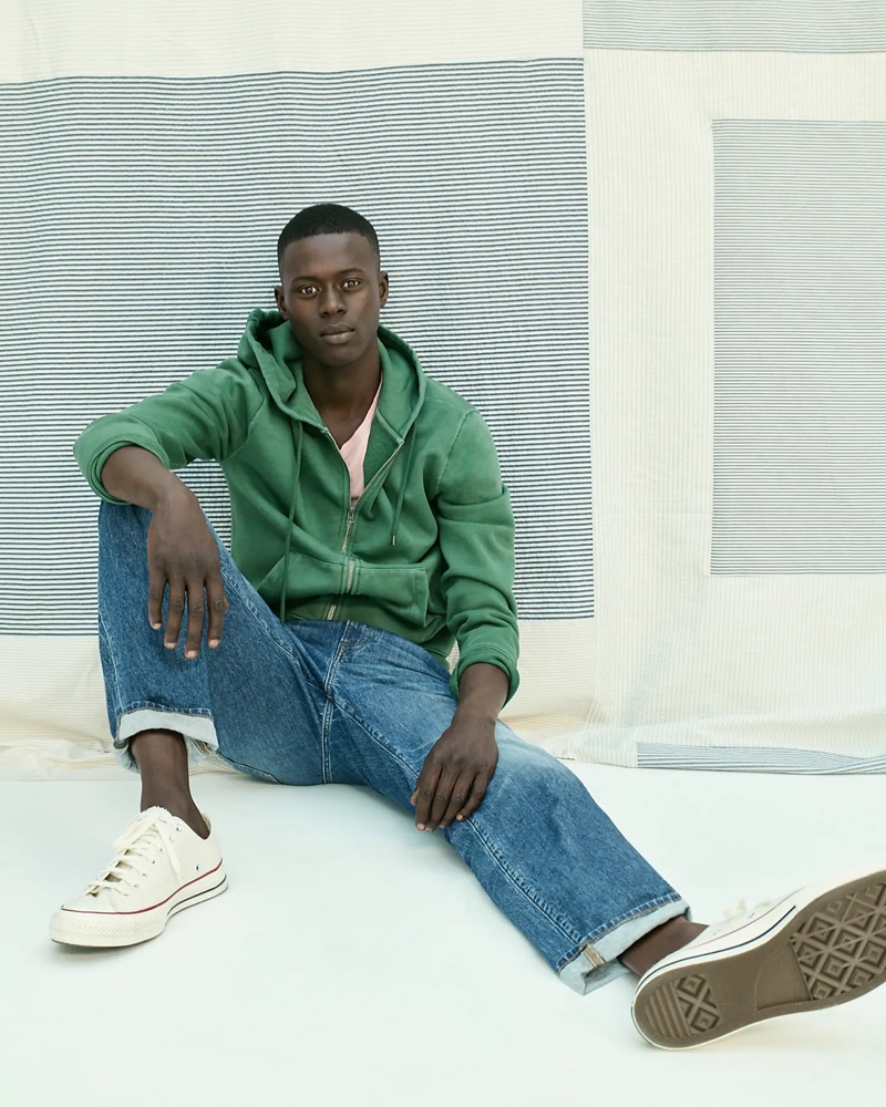 Going sporty, Alpha Dia wears a green J.Crew French terry full-zip hoodie, essential crewneck t-shirt, 1040 athletic-fit jeans, and Converse Chuck Taylor All Star '70 low-top sneakers.