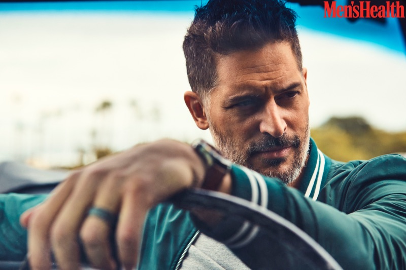 Getting behind the wheels of a car, Joe Manganiello wears an Eleventy jacket and Calvin Klein t-shirt with a Movado watch.