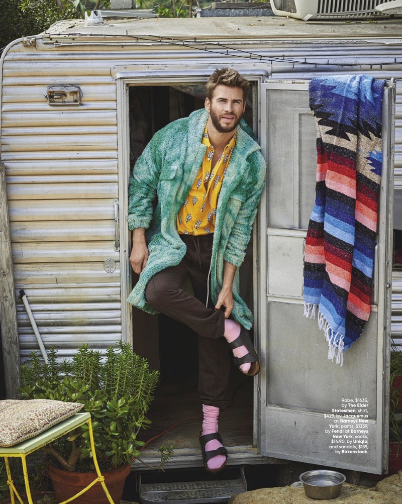 Donning quirky style, Liam Hemsworth wears a robe by The Elder Statesman. He also sports a Jacquemus shirt, Fendi pants, UNIQLO socks, and Birkenstock sandals.
