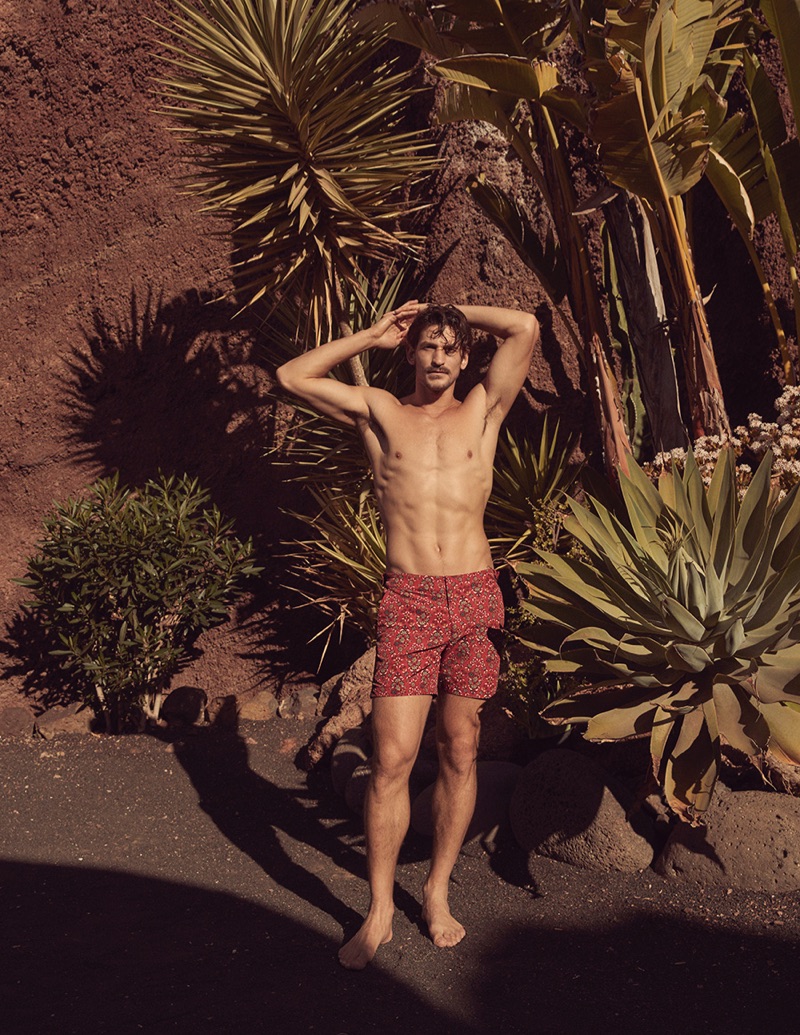 Australian model Jarrod Scott wears red patterned shorts from Liberty London's men's travel and swim collection.