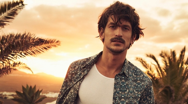 Jarrod Scott models a shirt and shorts from Liberty London's travel and swim collection.