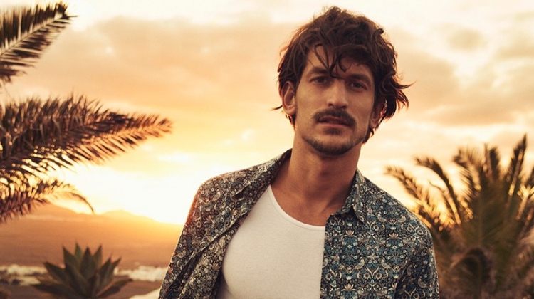 Jarrod Scott models a shirt and shorts from Liberty London's travel and swim collection.