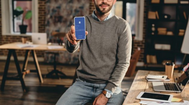 Using Facebook as a Source of Knowledge Man Sweater Jeans Facebook Phone