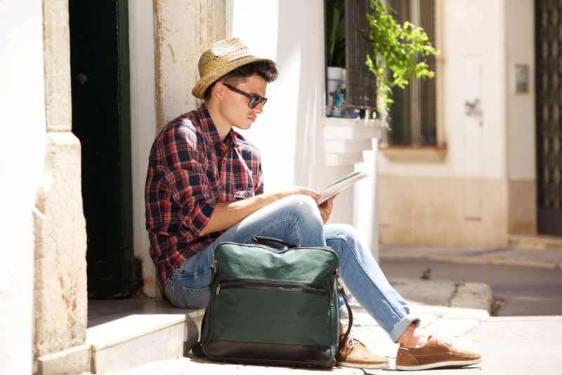 Man in Hat and Sunglasses Reading