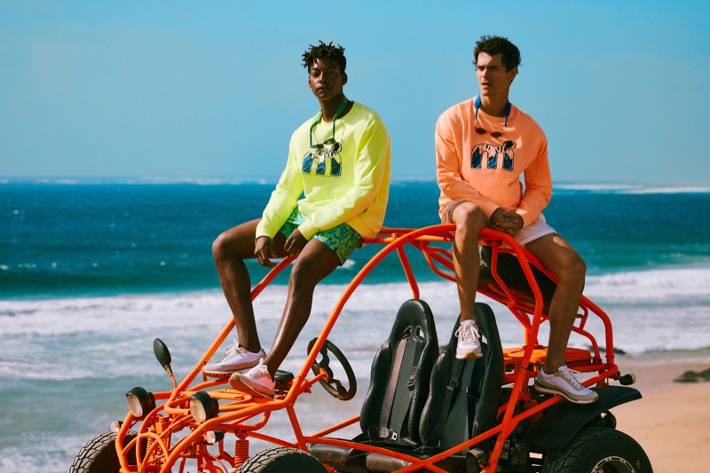 Taking to the beach, Ty Ogunkoya and Vincent LaCrocq sport highlighter-colored tees and swim shorts from Mango's Mistral collaboration.