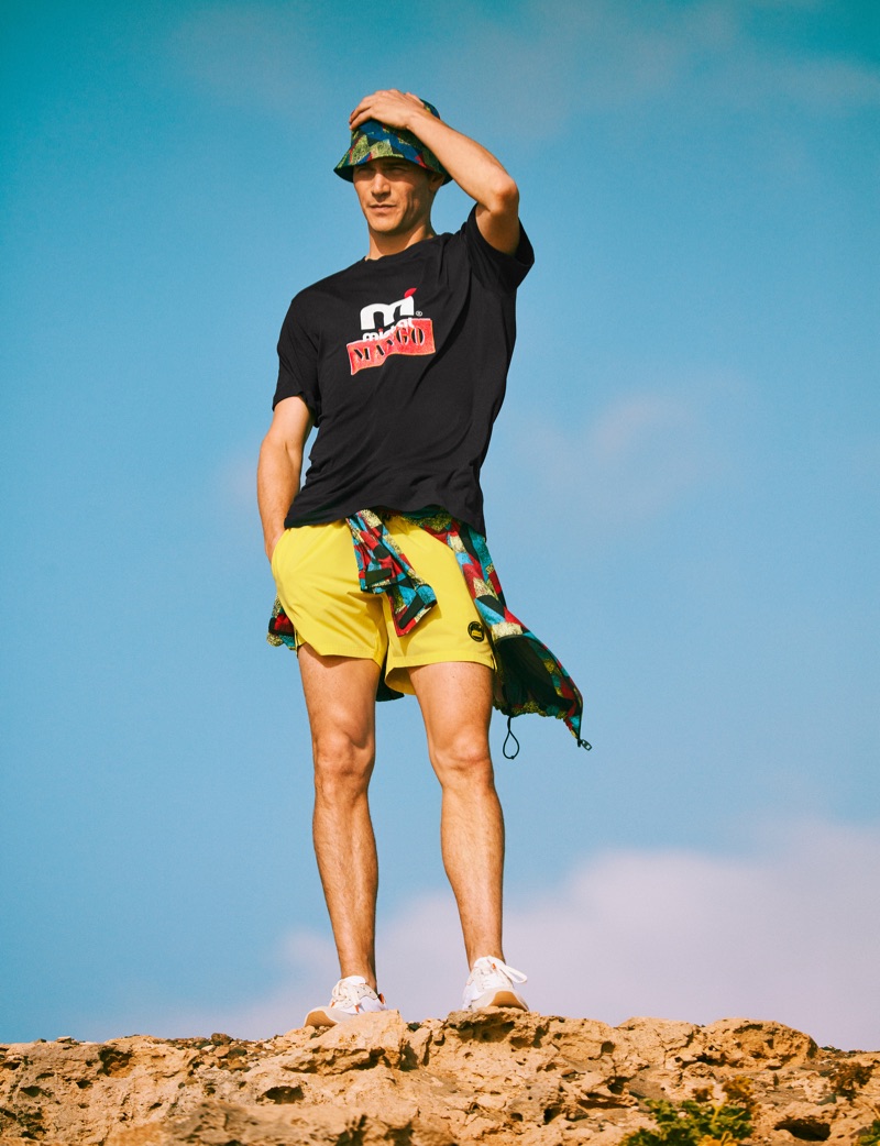Vincent LaCrocq embraces summer style in a t-shirt, bucket hat, and more from Mango's Mistral collaboration.
