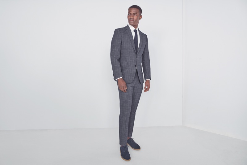 Donning a sharp suit, Kesse Donkor wears Marks & Spencer.