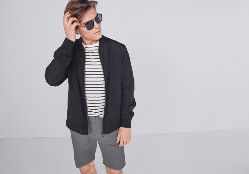 Sporting a bomber jacket, Oliver Cheshire wears a striped top and casual shorts from Marks & Spencer.