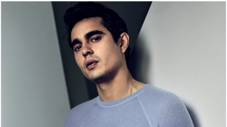 A chic vision, Max Minghella dons a sweater, belt, and pants by Giorgio Armani.