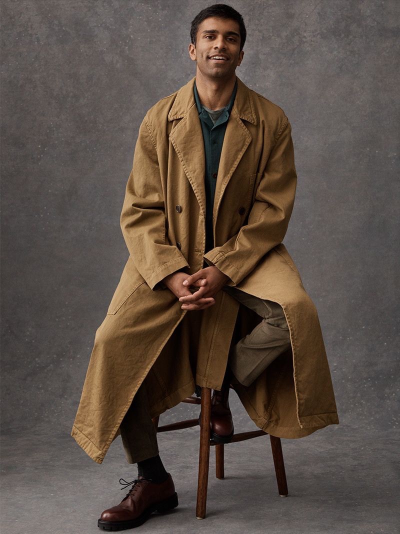 Sitting for a portrait, Nikesh Patel dons a Dries Van Noten trench coat, Mr P. camp-collar shirt, Etro t-shirt, and Thom Sweeney corduroy suit trousers. He also sports Mr P. derby shoes.