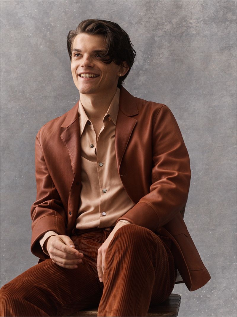 All smiles, Edward Bluemel wears a Loewe leather jacket, Save Khaki United shirt, and Séfr corduroy trousers.