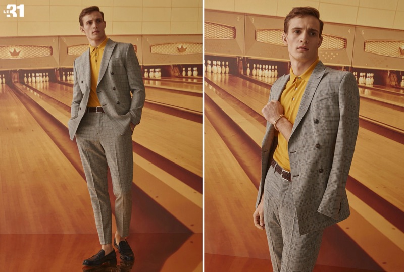 Julian Schneyder dons a LE 31 caramel Prince of Wales double-breasted jacket and suit pants with a dark yellow silky knit polo.