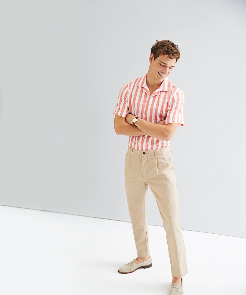 All smiles, Alexandre Cunha wears a Todd Snyder short-sleeve camp collar bold stripe shirt $158 in coral with linen Sutton suit trousers $228 in beige.