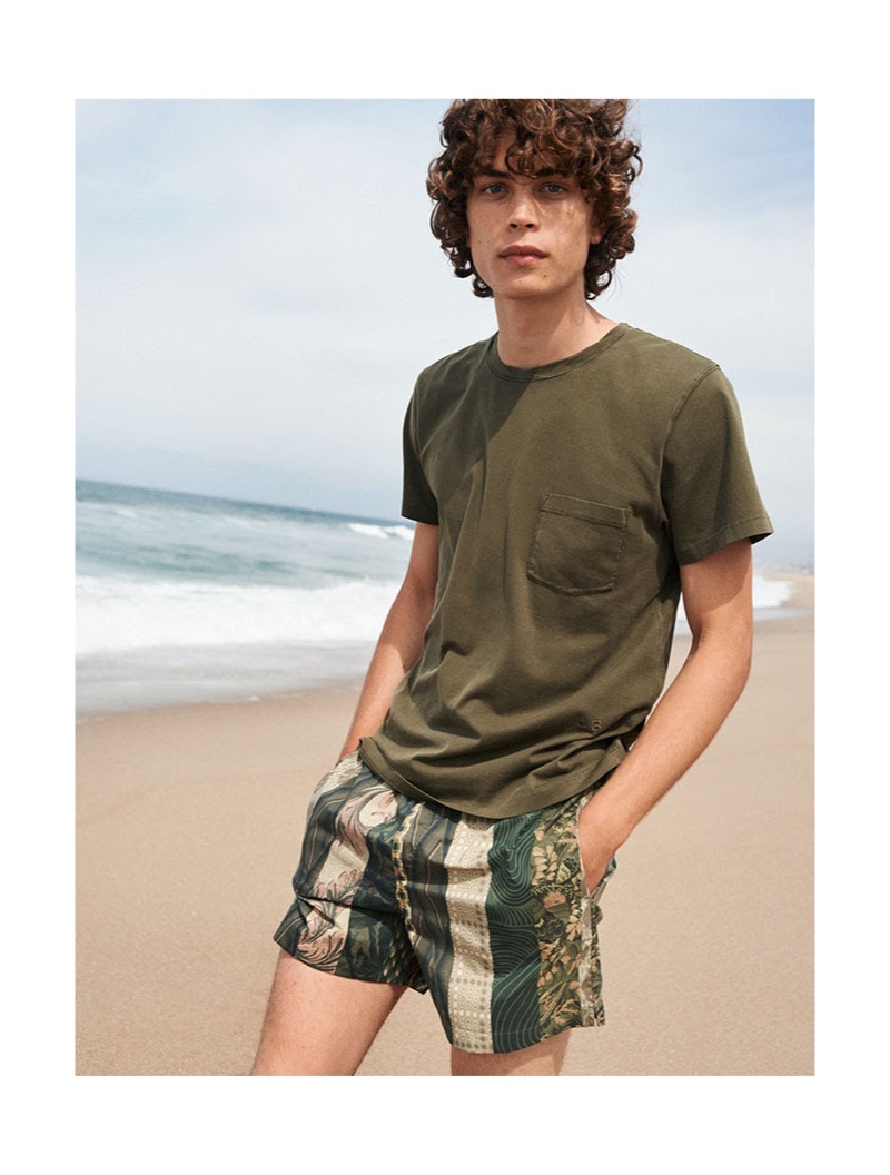 Hitting the beach, Lucas Bin sports military green Dries Van Noten swim shorts $244.