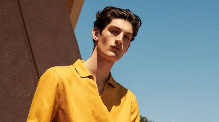 Aaron Shandel sports a yellow polo shirt and linen pants by Zara.