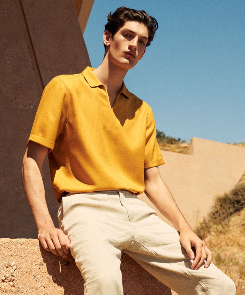 Aaron Shandel sports a yellow polo shirt and linen pants by Zara.