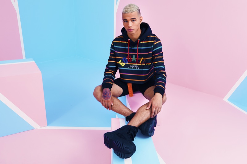Model Shae Pulver wears a striped hoodie from boohooMAN's 2019 Pride collection.
