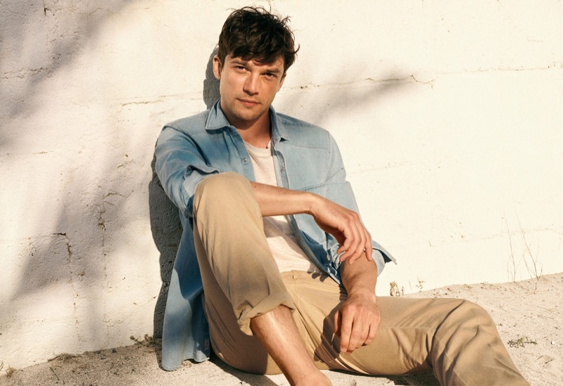 Embracing classic style, Alexis Petit wears a denim shirt with khaki pants from Mango.